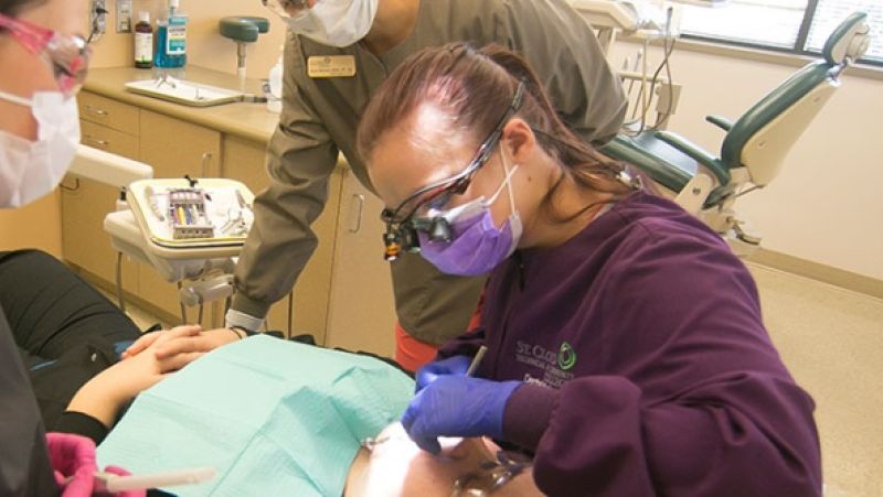 dental hygiene students working with a patient