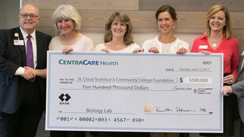 Administration holding large check for CentraCare donation
