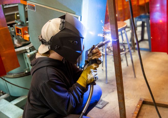 Welding student with sparks