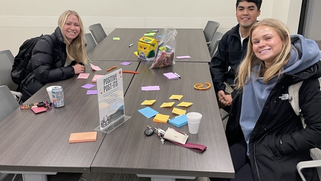 three students writing post-its