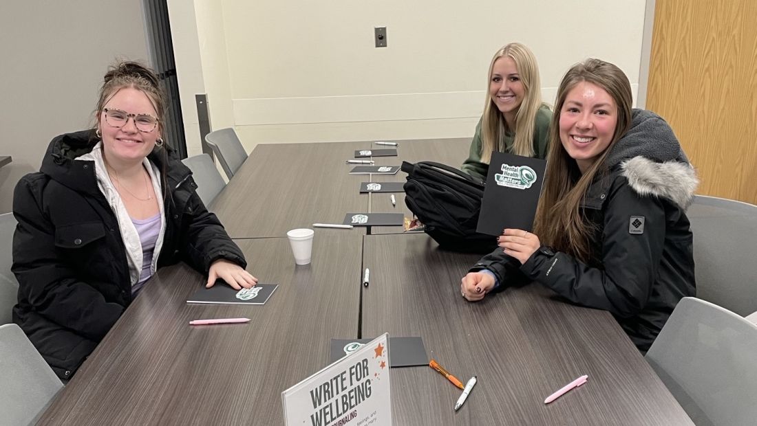 three students with the journal