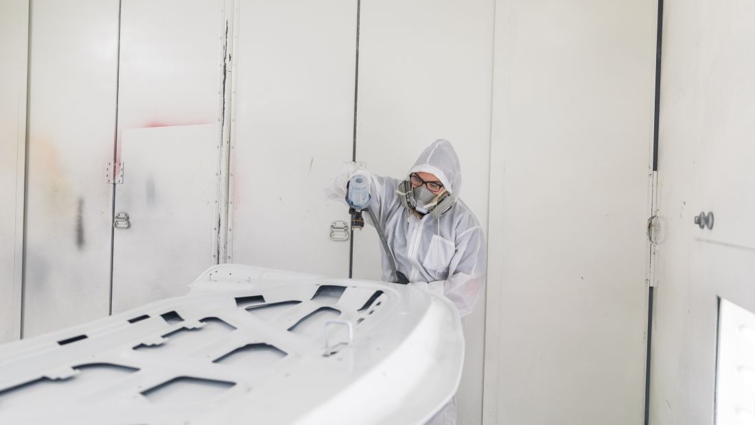 student painting panel of car