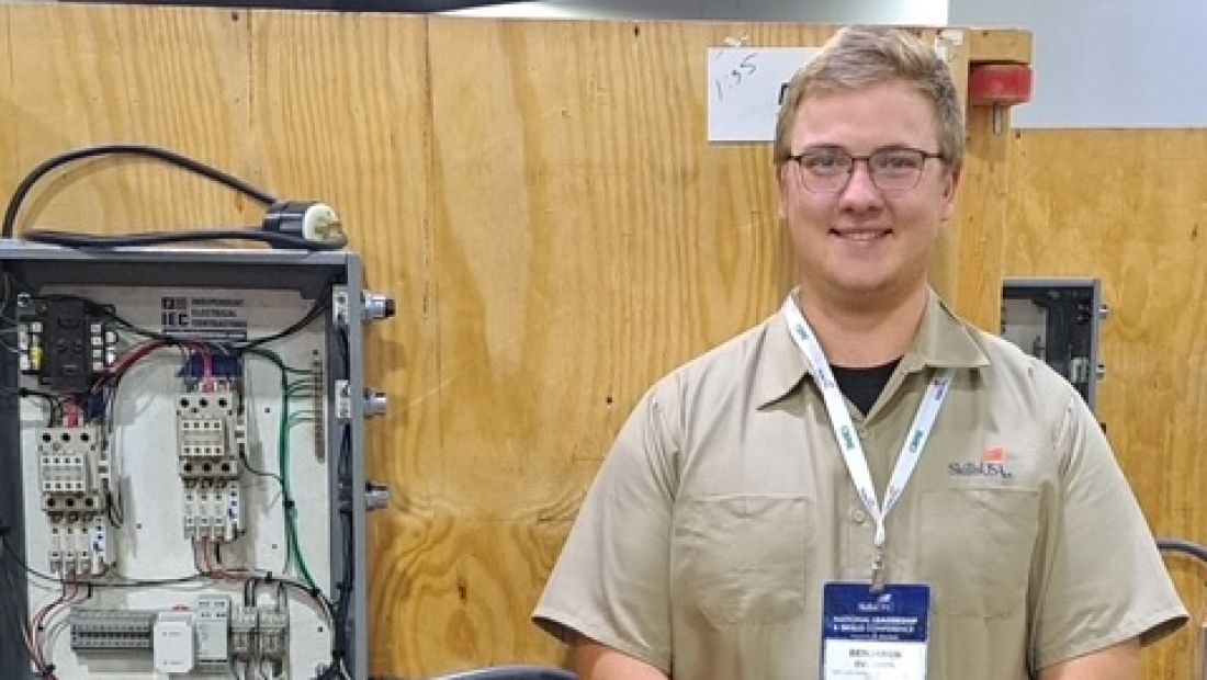 student standing with electrical panel