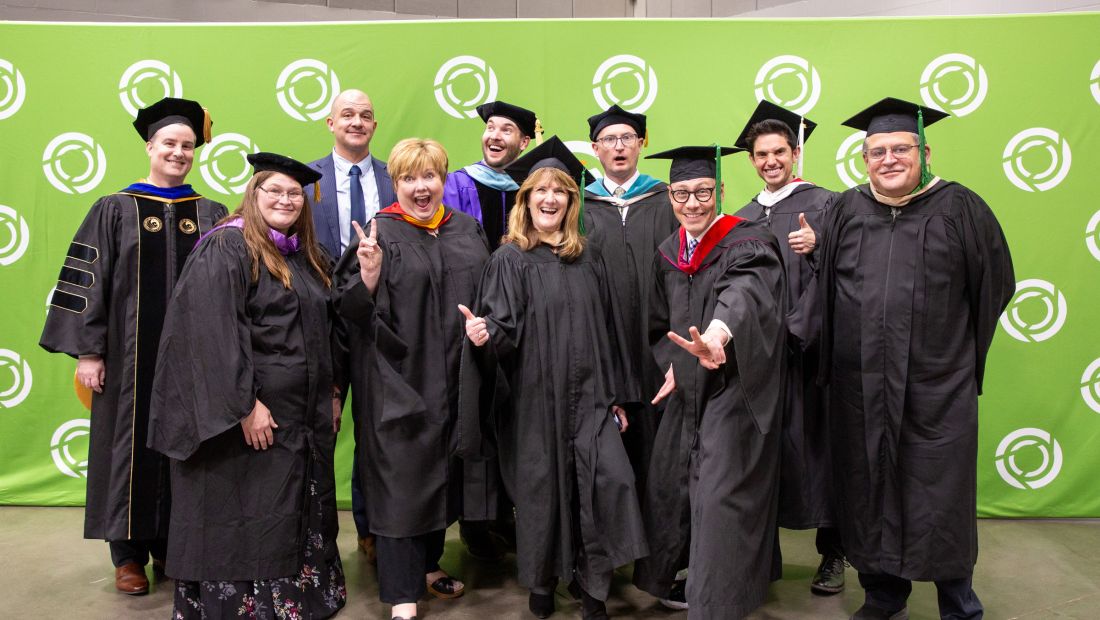 Kloos with the platform party posing goofy at commencement