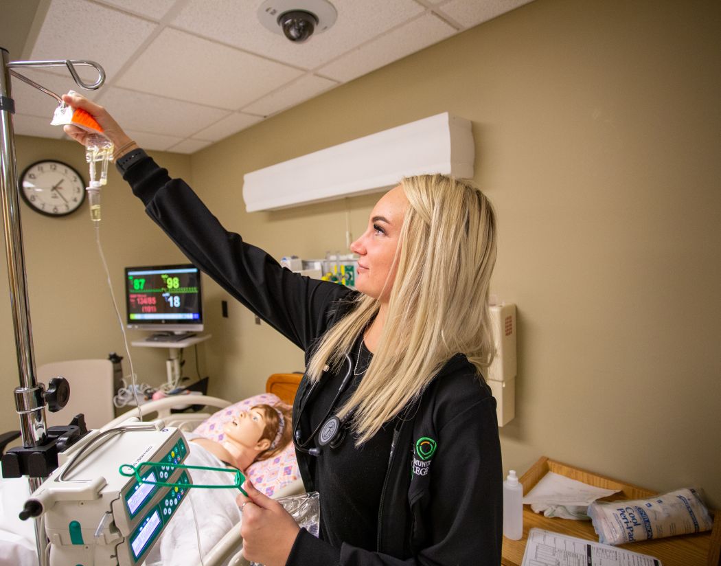 nursing student reaching to adjust IV