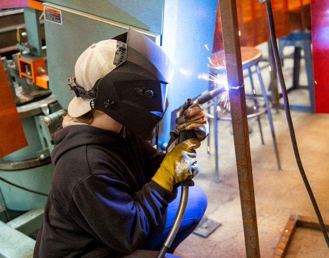 Welding student with sparks