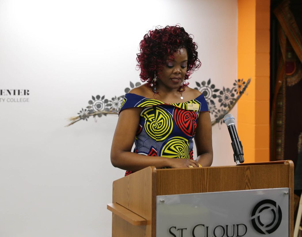 Njeri, a black woman, speaking at a podium