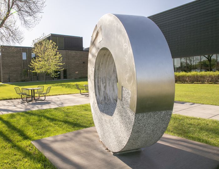 dounut with northway building in background, green grass and trees leafing out