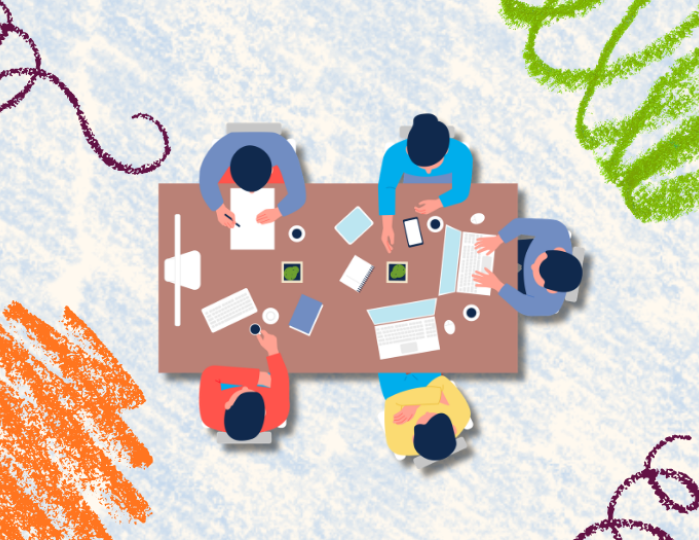 group of five people sitting around a table with various tasks, viewed from above