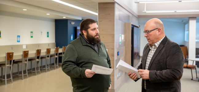 Business management student speaking to instructor