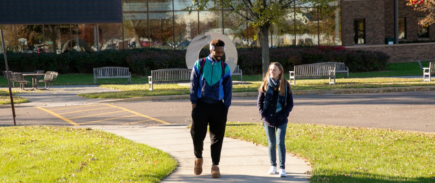 two students walking with Northway building in background