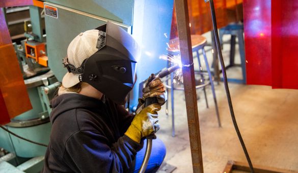 Welding student with sparks
