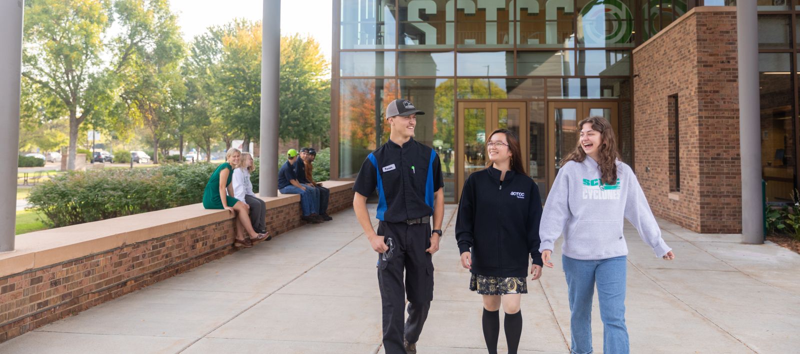 students walking outside door one with fall colors visible