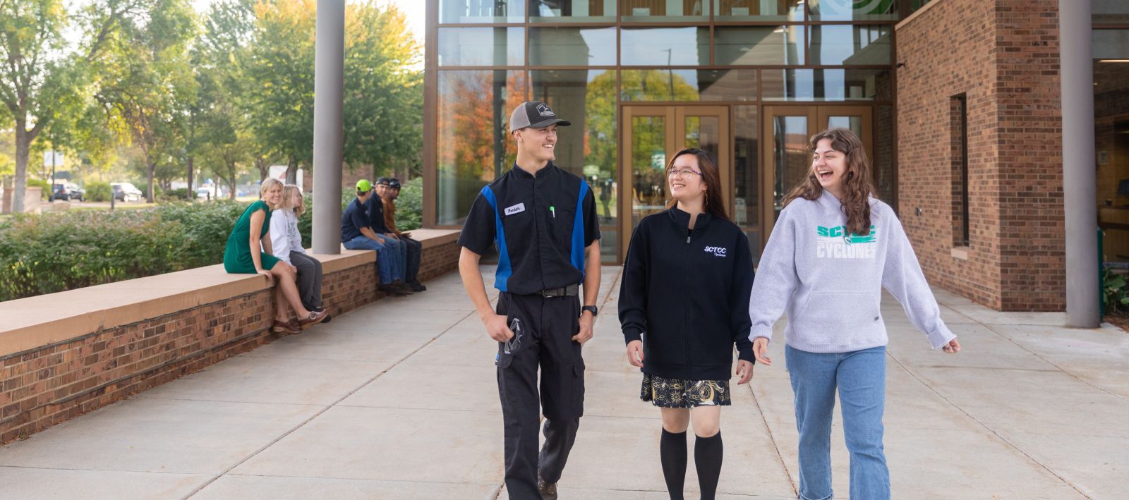 students walking outside door one with fall colors visible