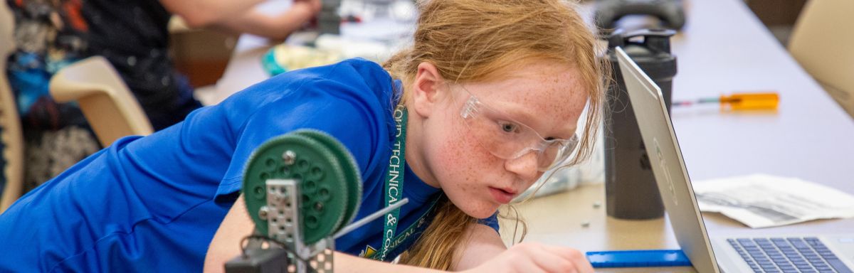 student focused on repairing robot