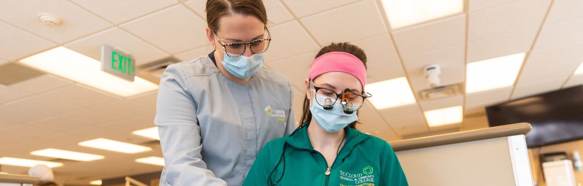 instructor guides dental hygiene student in practicing techniques 