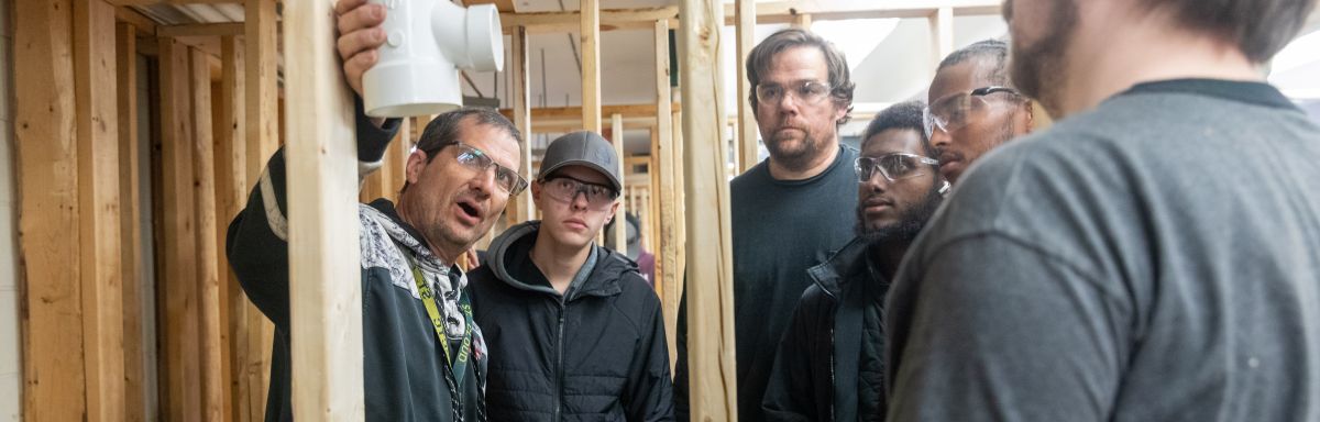 students listening as instructor explains placement of plumbing joint