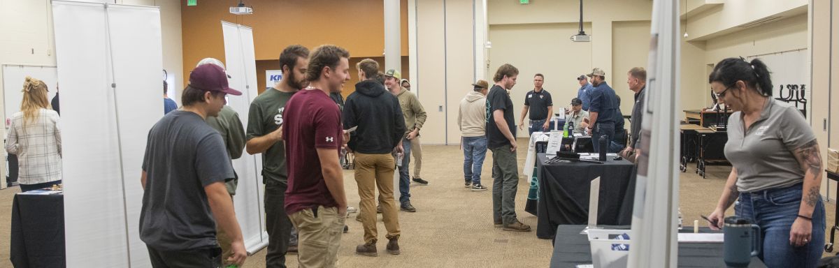 students walking and employeers set up at tables