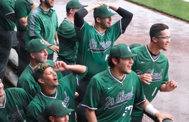 baseball players in dugout cheering