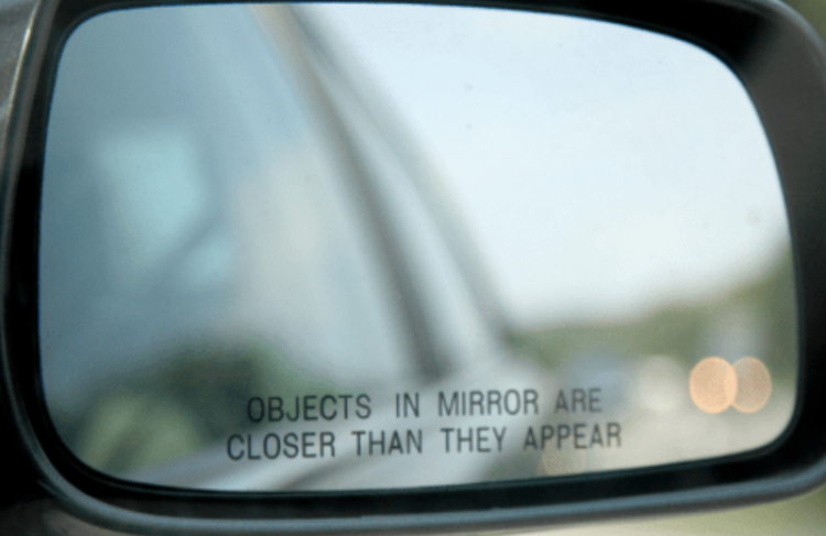 Photo of car side mirror saying "Objects in mirror are closer than they appear"