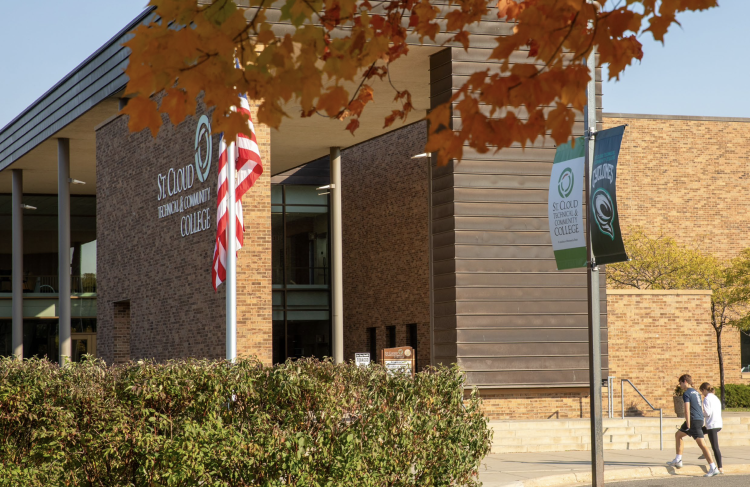 Front of SCTCC in fall with students stepping on sidewalk