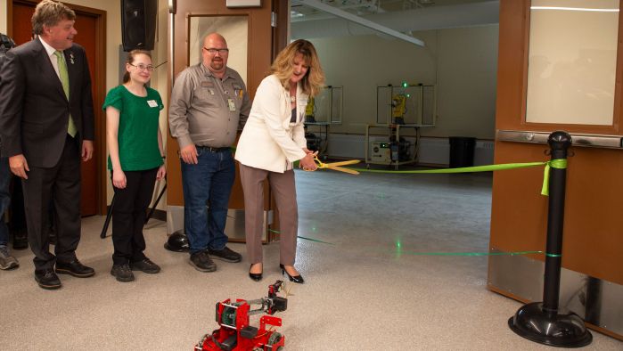 President Kloos, Aaron Barker, Katie Frank, and Chancellor Olson at ribbon with robot