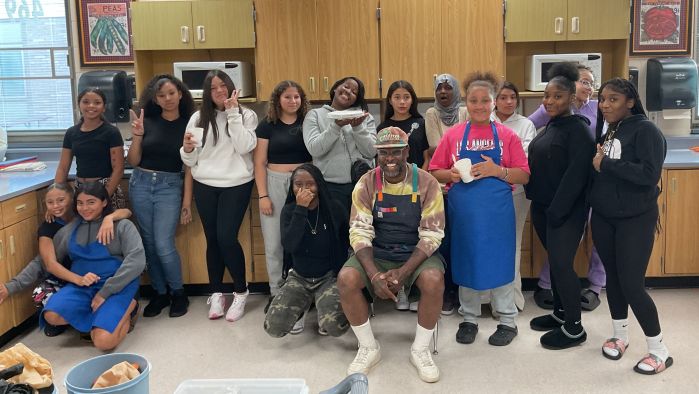 Group of middle school girls hamming it up for the camera with Chef Mateo 