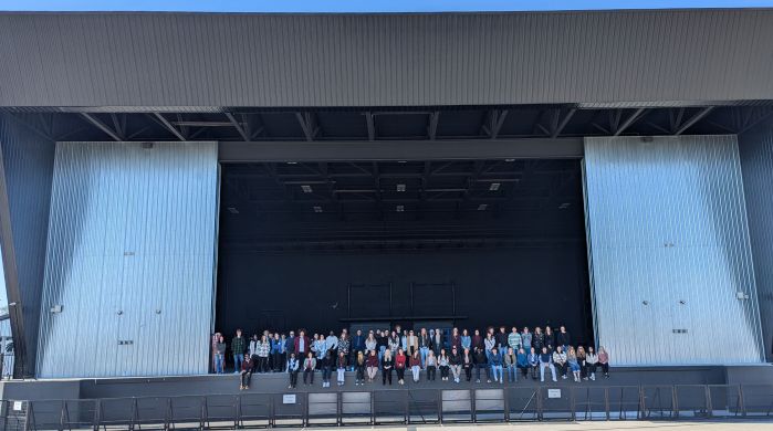 students sit on the stage at the ledge ampitheater