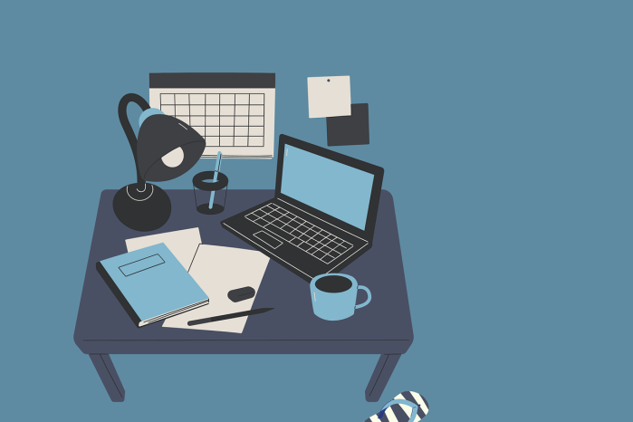 desk set up with lamp, planner, computer, notebook, and pen
