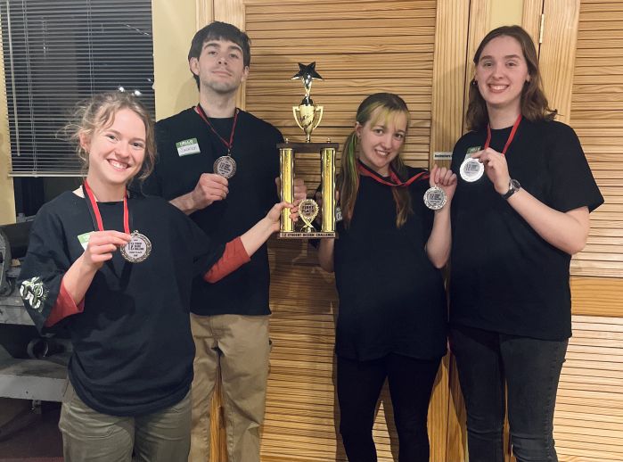 the four MKAD students who won the challenge with medals and a trophy
