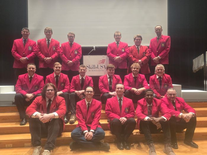 Large group of skills students and instructors in red jackets posing