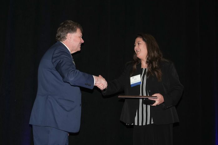 kelly crue accepted an award from chancellor olson