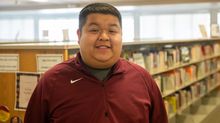 Aaron Seng smiling with library shelving in the background