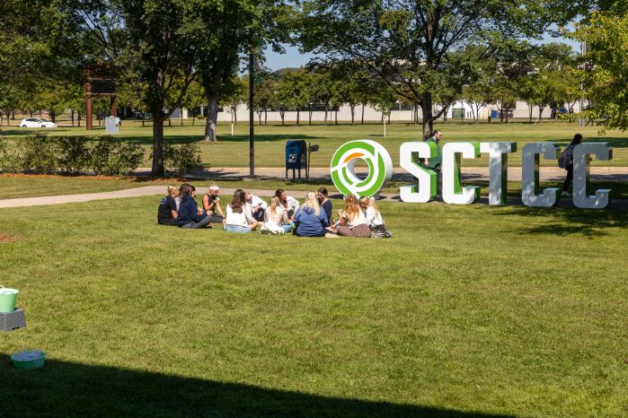 students sitting in the grass outside SCTCC