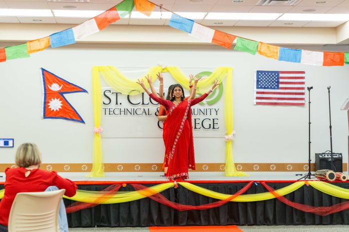 dancers dressed in red on the stage in the COmmons