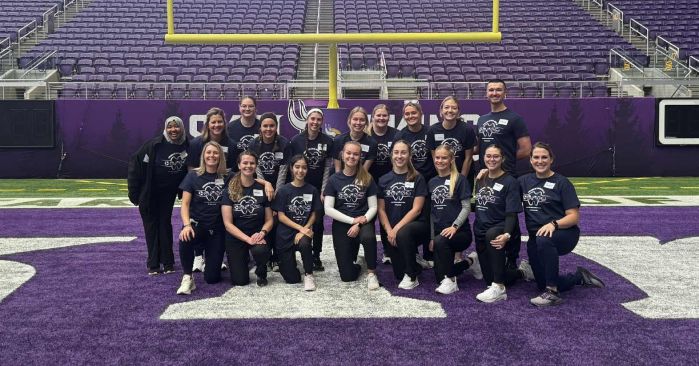 Dental hygiene students in three rows on the vikings field