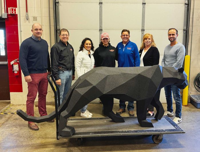 Group of people behind the welded panther smiling