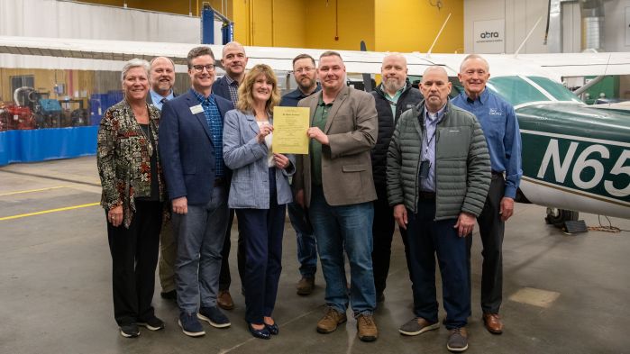 group of AMT advocates and FAA reps holding the SCTCC certificate in front of planes