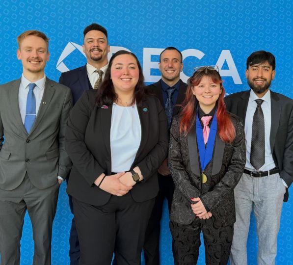 Deca team members in front of backdrop in two rows