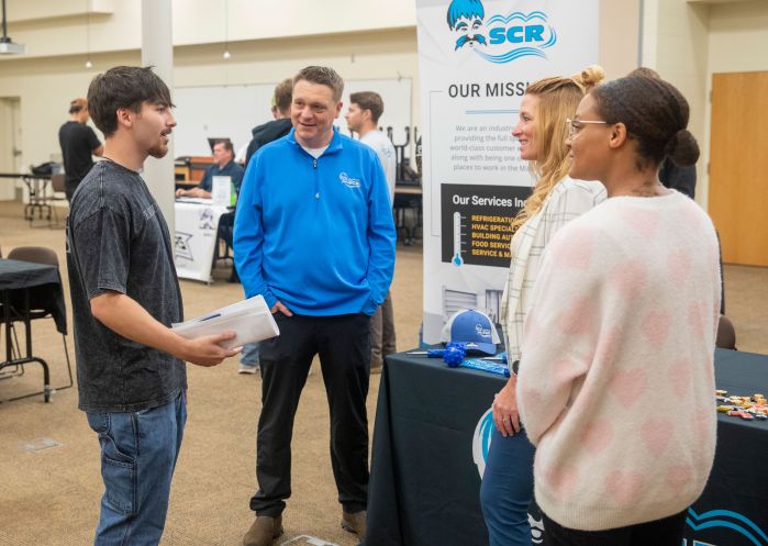 student talking with three reps from SCR about job opportunities