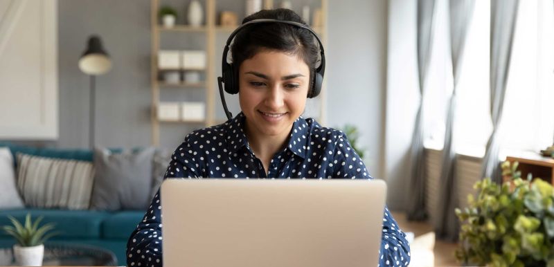 Woman with headset working on laptop at home