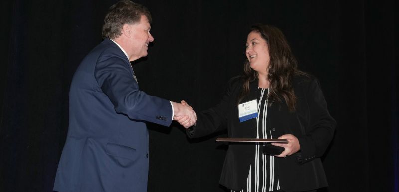 kelly crue accepted an award from chancellor olson
