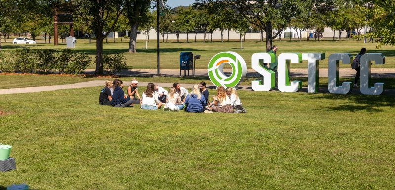 students sitting in the grass outside SCTCC