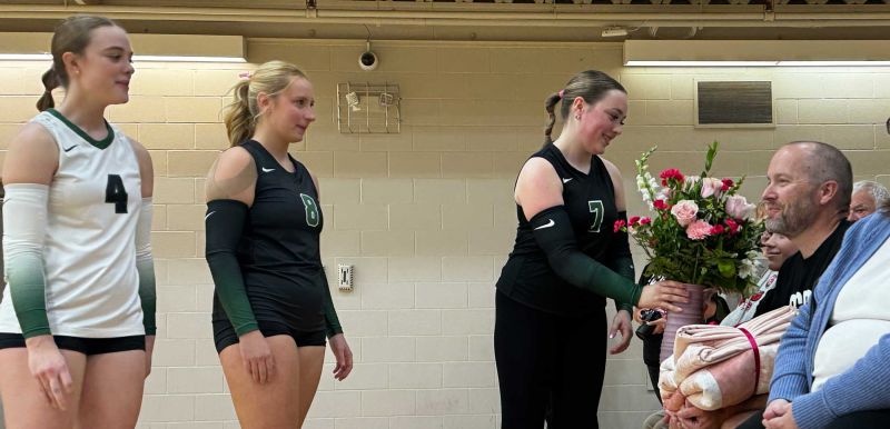Makenzie handing family members a bouquet at the game