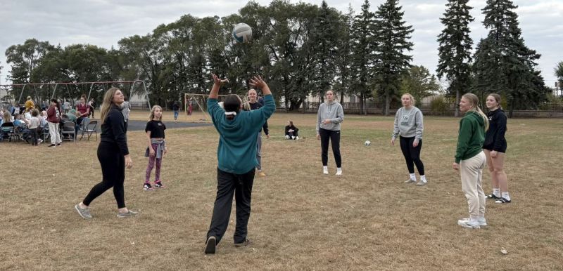 Volleyball team outdoors setting the ball in a circle