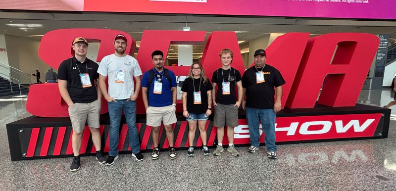 Five SCTCC folks in front of a giant SEMA statue