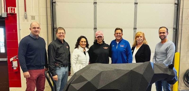 Group of people behind the welded panther smiling