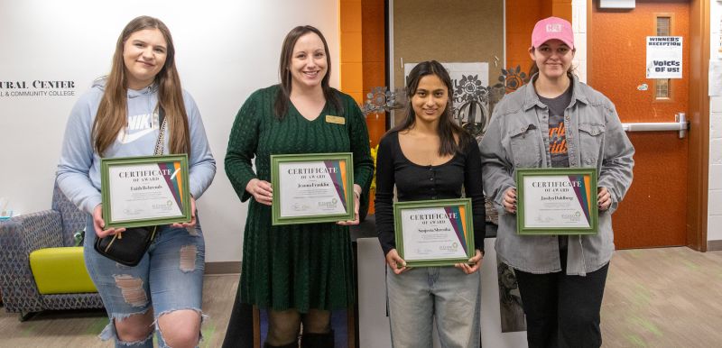 four winners of art contest holding their certificates