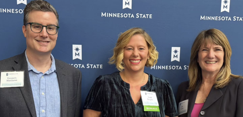 Ken, Kami, and Lori in front of a MinnSTate backdrop
