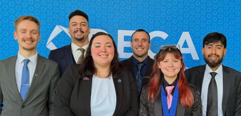 Deca team members in front of backdrop in two rows